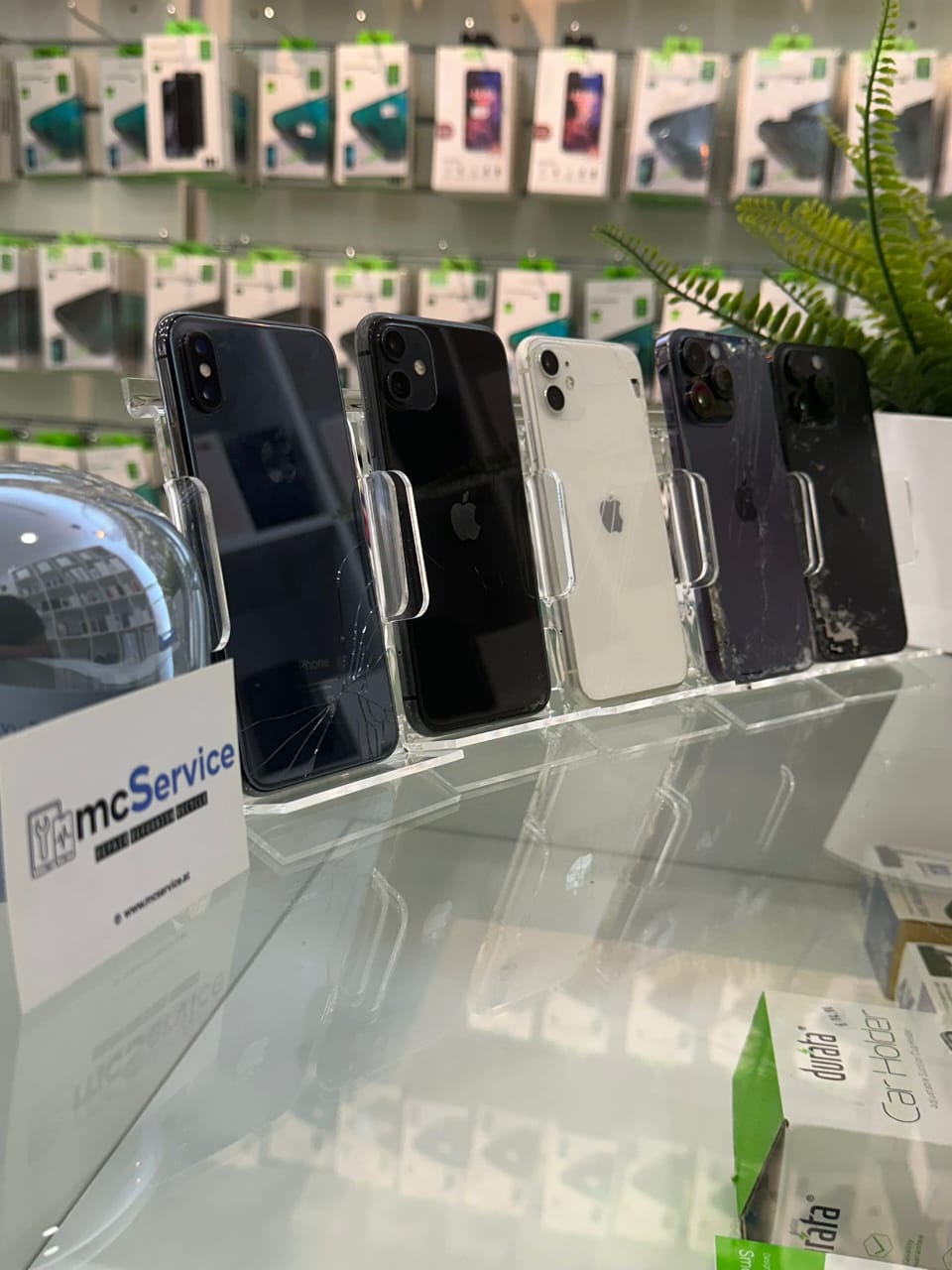 A box filled with used smartphones, arranged upright in dedicated slots.